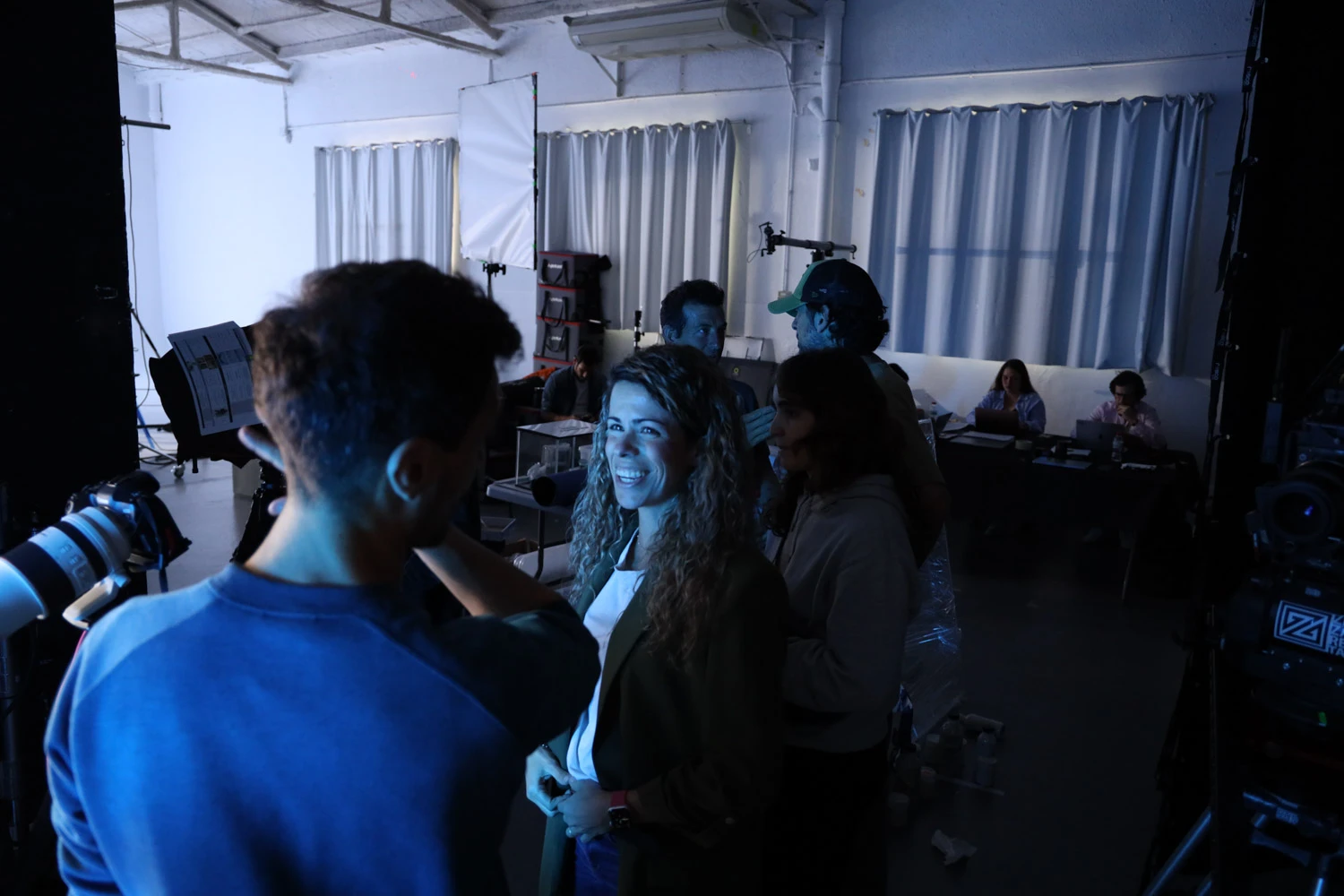 Tasty Studio crew chatting between takes in a studio lit in blue