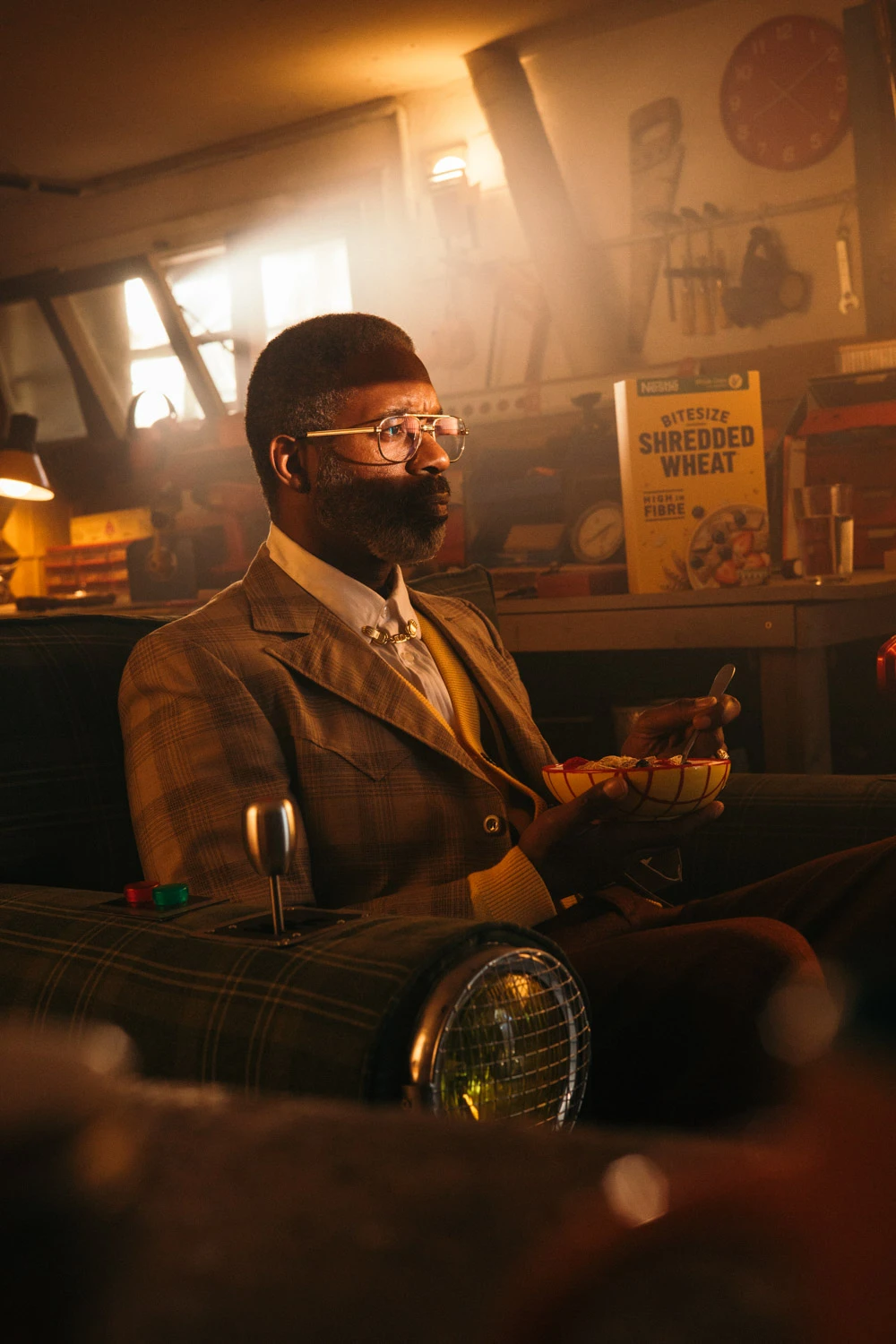 Man in a tweed suit with a bowl of cereal in a warm-lit garage, Shredded Wheat shoot