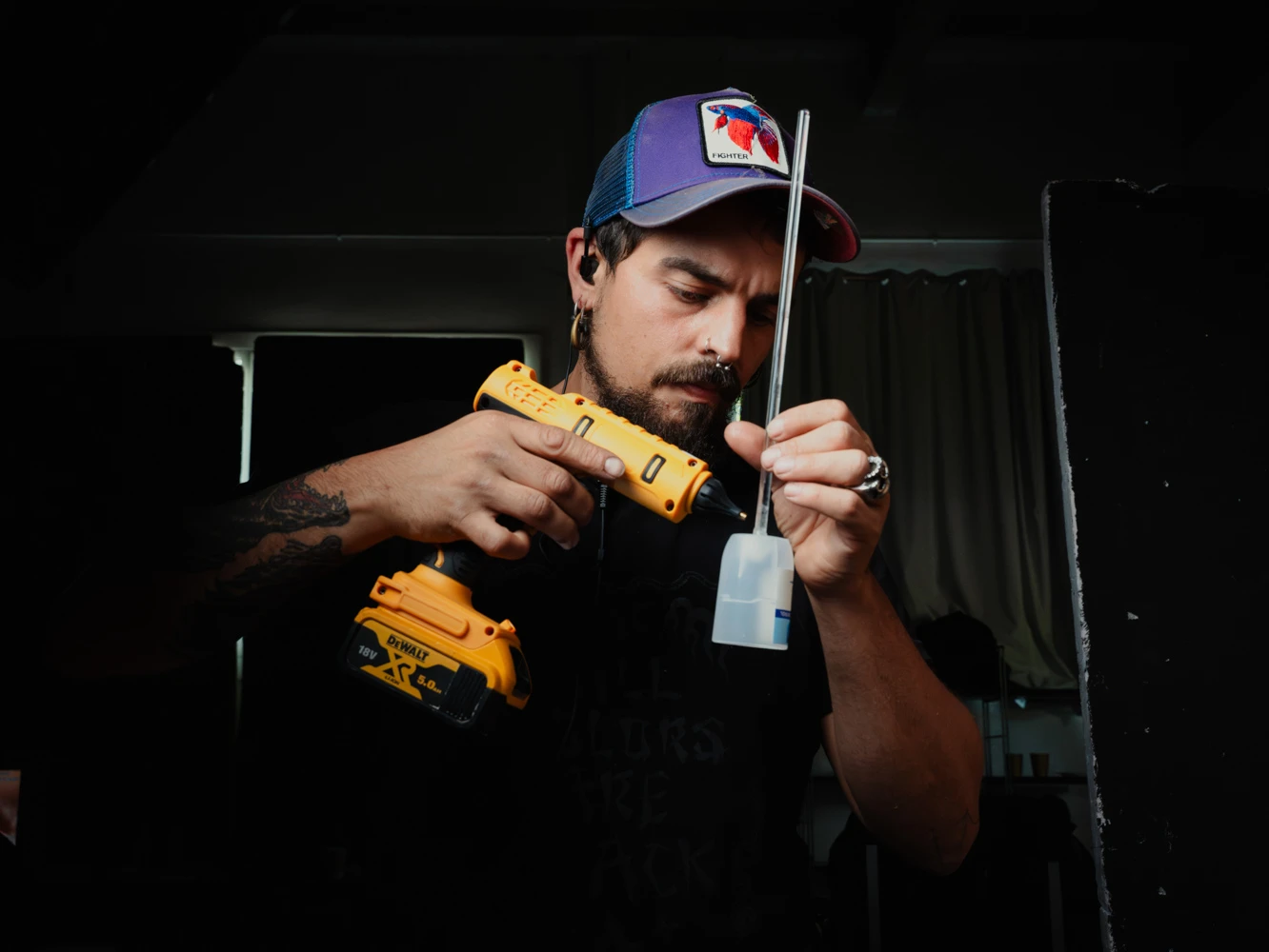 Tabletop technician using a glue gun to rig a small bottle for a Tasty Studio shot
