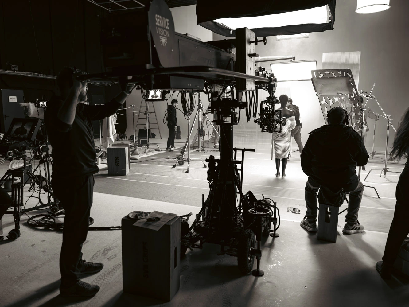 Telescopic camera crane and crew on a white studio set, in black and white