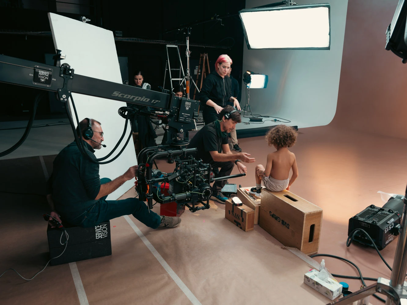 Equipo de Glassy Films con una grúa de cámara rodando a un bebé sentado sobre cajas de manzana